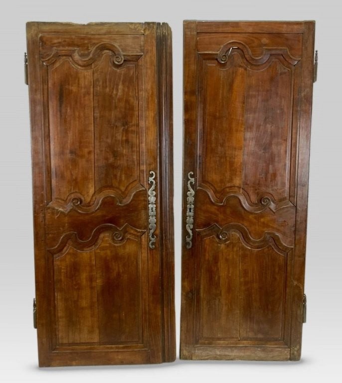 Pair of French Louis XV Revival Doors: This pair of walnut bonnetiere doors features a deep, beautiful rich patina and flowing carved scrollwork decoration, complete with an iron lock. For display or use. Measuring approximately 67 in. H x