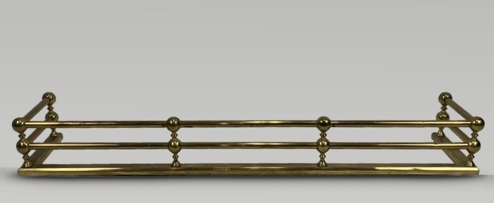 Brass Fireplace Fender: Luminous brass fireplace fender, featuring rounded baluster style decoration; approximately 6 1/4 in. H, 48 3/8 in. W, 11 1/2 in. D. Minimal surface wear.
