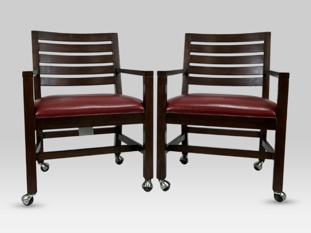 Pair of Ethan Allen Leather Upholstered Chairs: This pair of Mission-inspired Ethan Allen chairs features a slat-back construction with wood finished in dark tones and red leather upholstery. Each chair is fitted with modern metal casters.