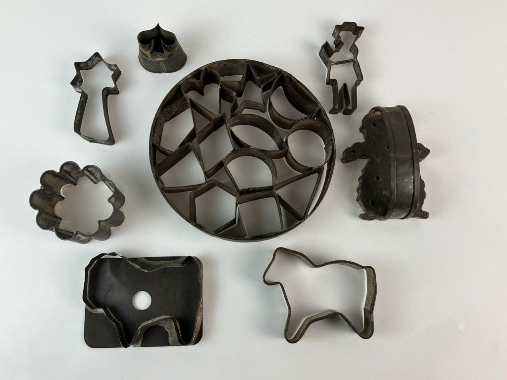 Assortment of Tin Cookie Cutters: Consists of primitive country-style forms in a variety of shapes, including one marked by Davis Baking Powder. The largest form measures approximately 1 1/4 in. H x 6 5/8 in. in diameter. All pieces s