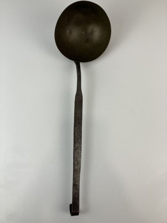 Brass and Wrought Iron Ladle: 19th-century ladle features a hand-wrought iron handle with a curved end and a curved brass bowl. It measures approximately 16 7/8 in. H x 5 in. in diameter, including the bowl. The piece exhibits