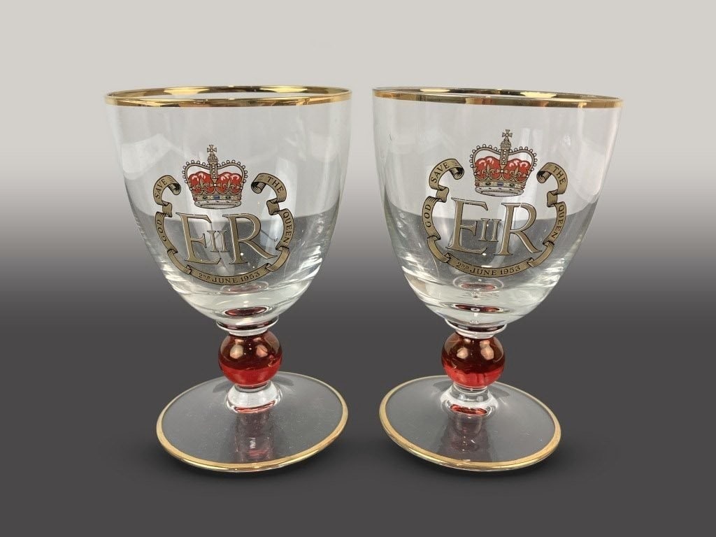 Pair of Queen Elizabeth II Commemorative Coronation Goblets: This pair of glassware commemorates the coronation of Queen Elizabeth II on June 2, 1953, featuring an elegant form accented with a gilt-decorated edge. One goblet measures approximately 5 1/4 in. H