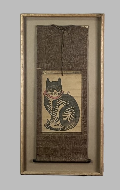 Japanese Kakemono Cat Woodblock Print: This traditional hanging scroll (kakemono) features a woodblock-printed design of a seated tabby cat wearing a red collar, set against a background with a wood grain pattern. Housed in a wood frame,