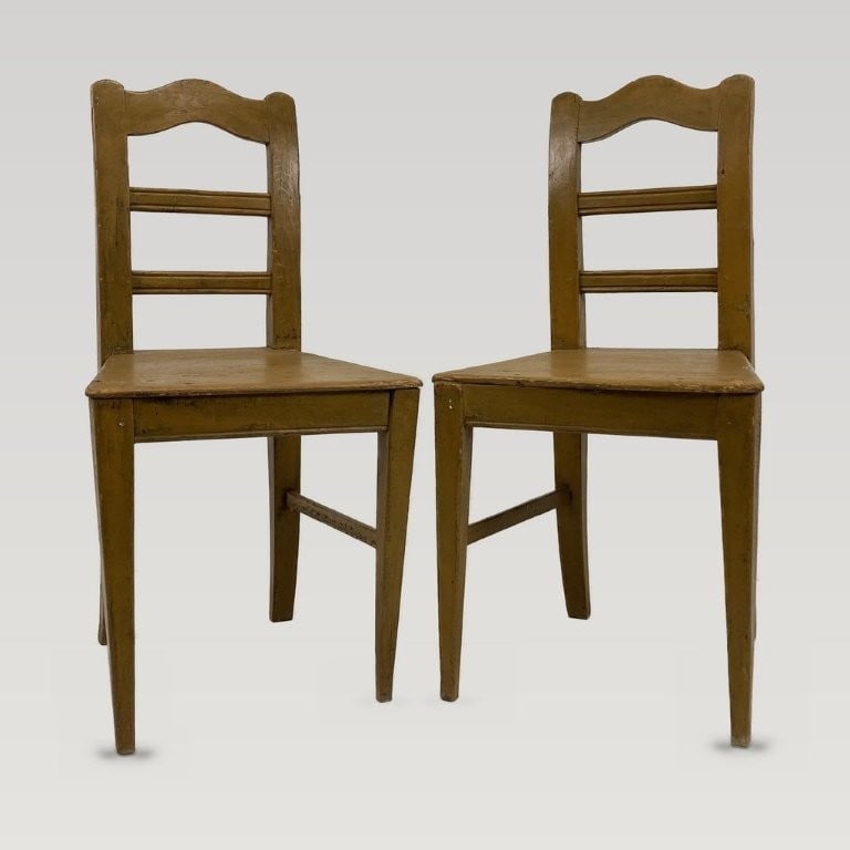 Pair of Painted Country Chairs: This pair of country ladder-back chairs features a sunny, deep yellow painted finish, shaped crest rails, and tapered legs. One chair measures approximately 36 1/4 in. H x 17 7/8 in. W x 15 3/8 in. D