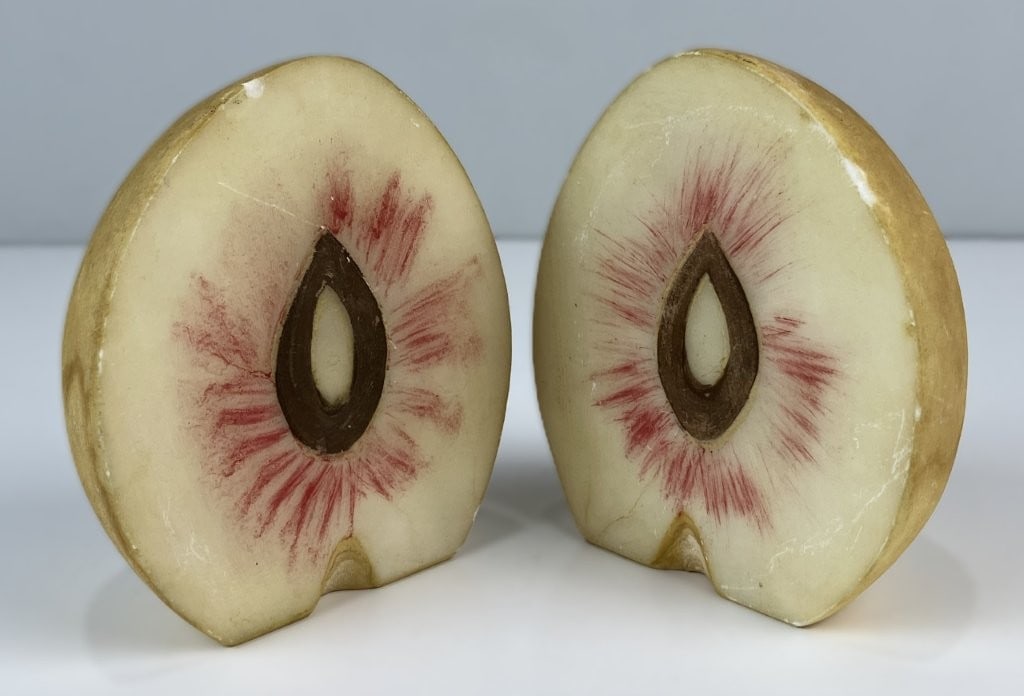 Carved Stone Fruit Bookends: Charming pair of vintage decorative bookends features carved alabaster slices styled as fruit with hand-painted polychrome finishes. One piece measures approximately 4 1/8 in. H x 3 5/8 in. W x 1 3/4