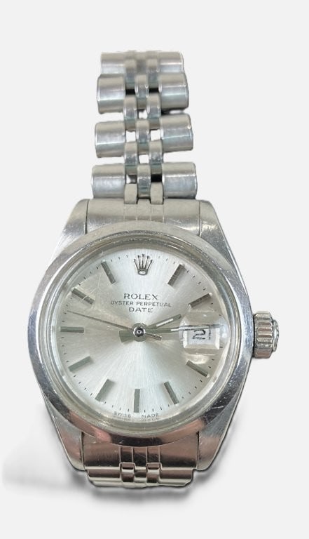 Ladies Rolex Oyster Perpetual Date Wristwatch: Luxury timepiece features a classic mid-century design, characterized by a stainless steel case with a smooth bezel and a sunburst dial. It is paired with a Jubilee-style link bracelet. Dimensions: