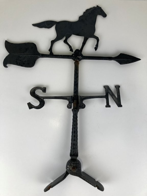 Running Horse Weathervane: Striking structural weathervane features a robust cast metal running horse silhouette mounted above traditional directional coordinates displaying N and S orientation. The piece carries a dark,