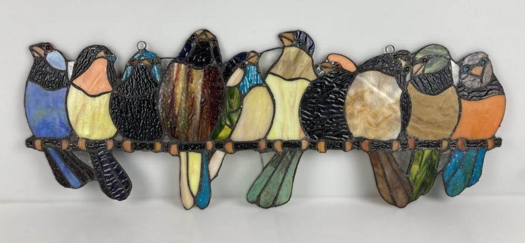 Stained Glass Birds Decorative Wall Plaque: This vibrant stained glass wall plaque features a charming horizontal composition of a line of colorful birds perched together on a branch. The handcrafted piece incorporates a rich assortment of