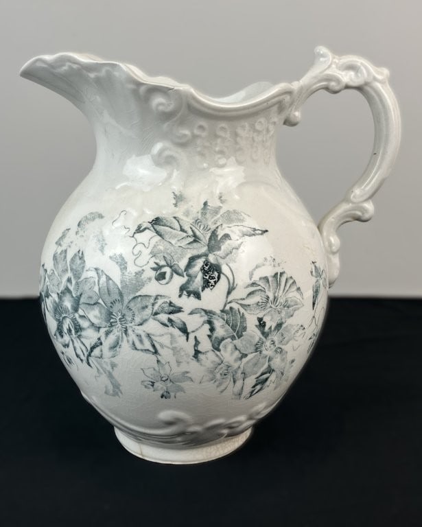 Decorated Ironstone Pitcher: This late 19th-century American ironstone pitcher was produced by the Wheeling Pottery Company of West Virginia. The robust, curving form is adorned with deep blue transferware patterning,