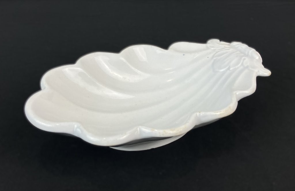 Shell Ironstone Dish: This 19th-century ironstone dish, manufactured by Thomas Hughes, features the classic De Soto Shell pattern with an elegant scalloped edge and a crisp white finish. Versatile and decorative, it can