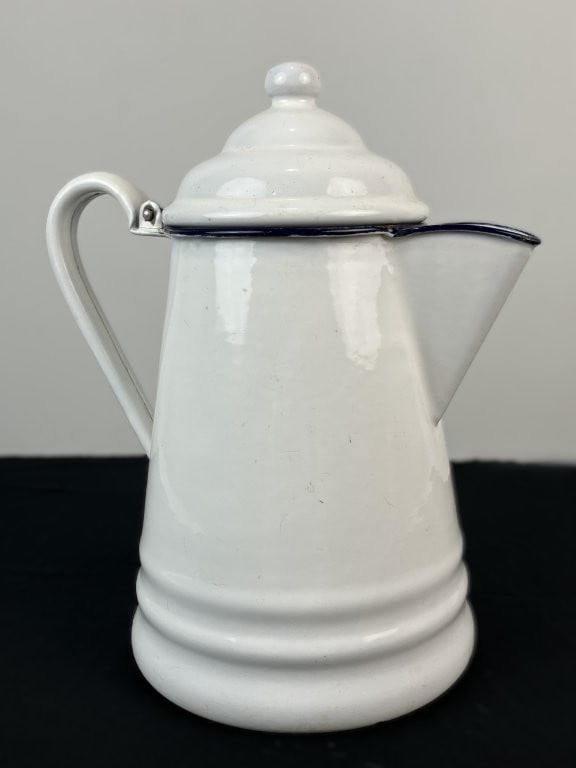 White Enamelware Coffee Pot: This white enamelware coffee pot is fitted with a matching lid topped with a rounded finial, a classic pouring spout, and a sturdy handle. The crisp white body is accented with contrasting