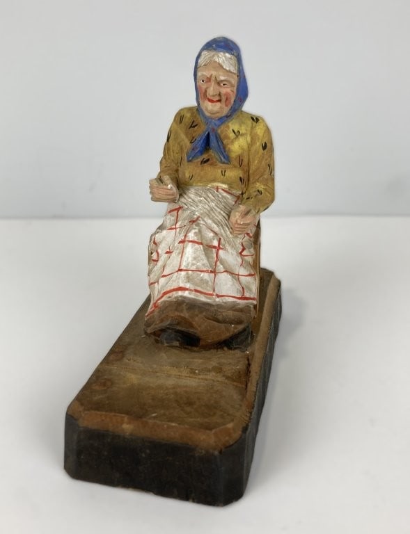 Folk Art Polychromed Grandma Wood Carving: Charming folk art wood carving depicts a sweet grandmother figure, expertly hand-carved from basswood with wonderful artisan detail. The piece features intricately patterned painted clothing and