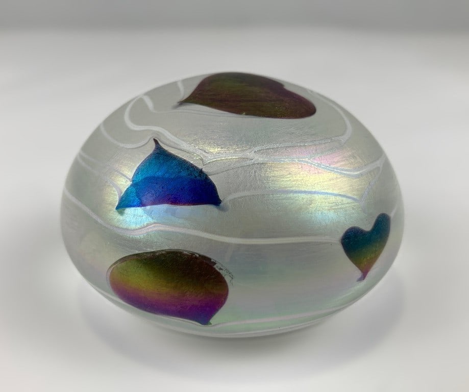 Iridescent Art Glass Heart and Vine Paperweight: Captivating art glass paperweight features a luminous frosted white iridescent ground adorned with an intricate, organic motif of swirling vines and iridescent multi colored hearts. The iridescent