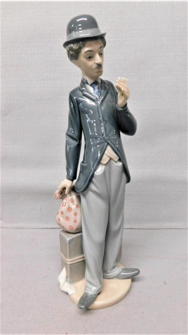 Lladro Figurine: 11in.H. Lladro Figurine of "Charlie Chaplain" Type Man w/Suitcases looking at Flower, marked No.N 90