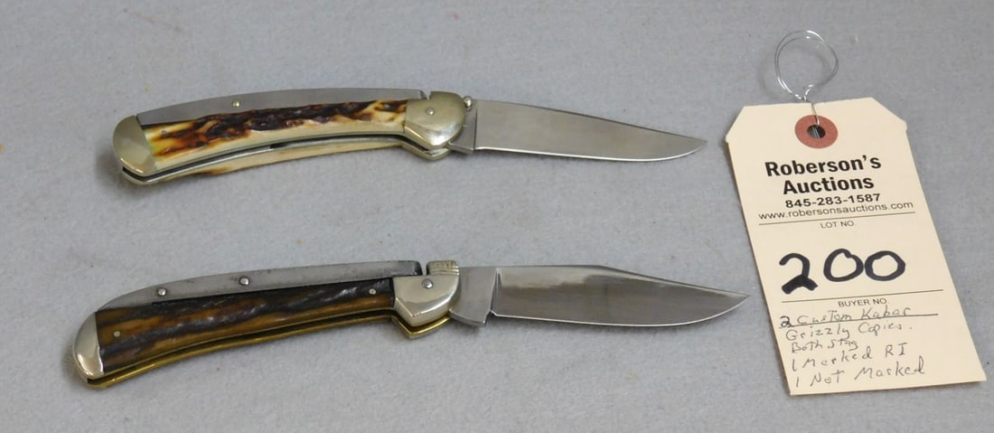 2 - Custom Kabar Grizzly Knife Copies: 2 - Custom Kabar Grizzly Knife Copies: 1 - 4 1/2" Closed with stag handles, no cracks, fires well, slight wobble, blade stamped RI; 1 - 4 3/4" closed, stag handles, no stamp on blade, no wobble, both