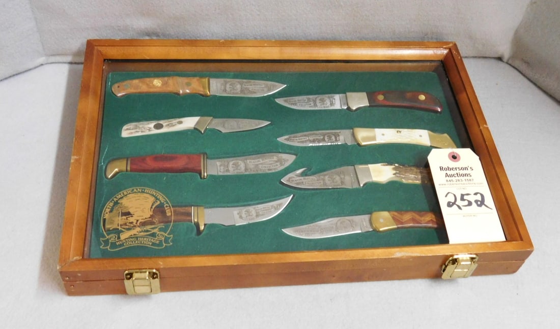 North American Hunting Club Knives: North American Hunting Club Knives - "Hertiage Collection For Life Members" w/8 Sheath Knives in Display Case in VG Cond. Case - 18" x 12" x 2" (Beautiful Set ) Knives Range 6 5/8" to 9 1/2"