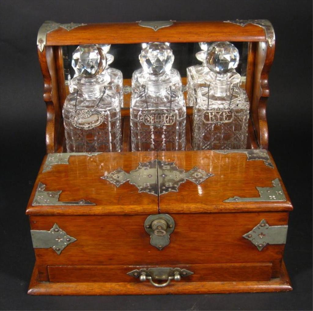Victorian Tantalus & Game Set 19th Century: Victorian Tantalus Set, Probably American or British, Late 19th C., the silverplate-mounted oak case contains 3 cut glass decanters with stoppers and 12 cordial glasses in two sizes (5 large, 8 small)