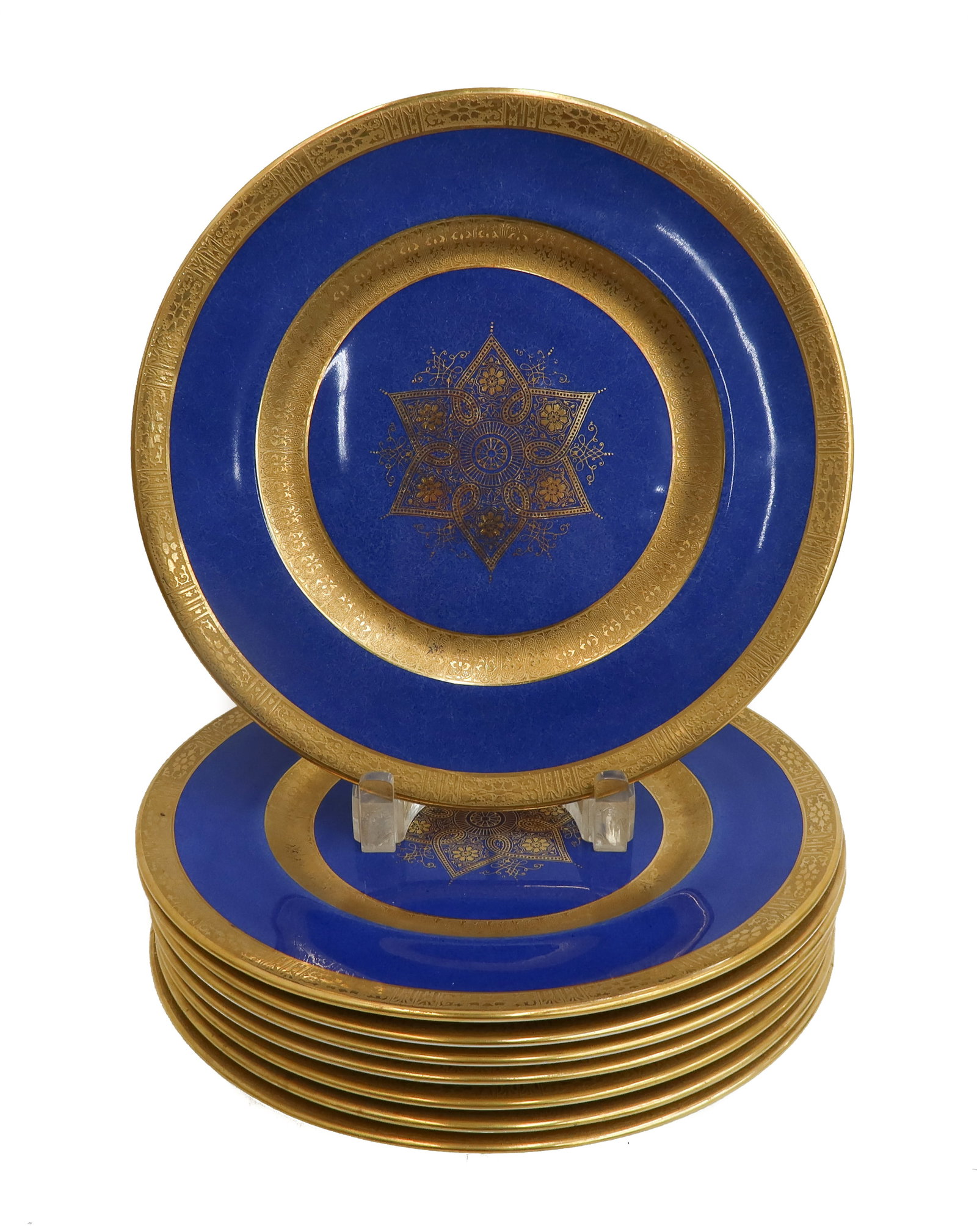 8 Royal Doulton England Porcelain Cobalt Blue and Gilt Dinner Plates circa 1930: 8 Royal Doulton England Porcelain Cobalt Blue and Gilt Dinner Plates, circa 1930. Powdered Cobalt blue ground with gold encrusted circular bands to inner and outer rim. A floral emblem to center Royal