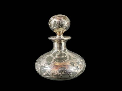 Sterling Silver overlay on glass Perfume Bottle: Sterling Silver overlay on glass Perfume Bottle, Floral openwork overlay, glass stopper. Vacant cartouche. Marked 'Sterling' (very faint.)Measurements: Approx. 3.5 inches height x 3.25 inches diameter