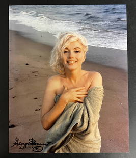 Color Photograph Marilyn Monroe by George Barris: A limited edition George Barris photograph of Marilyn Monroe. Signed by George Barris in marker (lower left). Stamped and numbered on reverse. Marilyn Monroe at Santa Monica Beach in 1962, holding a t