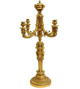 French Gilt Bronze 4 arm Candelabra circa 1920: French Gilt Bronze Candelabra. 4-armed candelabra, figures of women to the stem, faces decorating the ends of the arms. Pinecone finial to the top. Underside with impressed numbers. Weight: Approx. 13