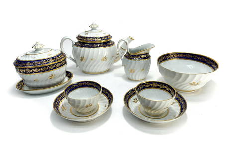 English Porcelain Tete-a-Tete Tea Service, Cobalt Blue & Gilt, Early 19th Cent.: English Porcelain Tete-a-Tete tea service, Early 19th Century. Swirled ribbed texture with cobalt blue and gilt leaf designs to the rim. Unmarked. Weight: Approx. 5 lbs Measurements: Approx. Teapot: 1