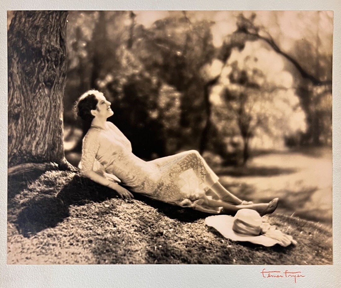 Elmer Fryer Sepia Tone photograph of Actress Billie Dove c1930: Elmer Fryer (American 1898-1944) Sepia Tone silver gelatin photograph, Film actress Billie Dove (American 1903-1997), reclining under a tree; signed lower right on board the photo is mounted to. Iconi