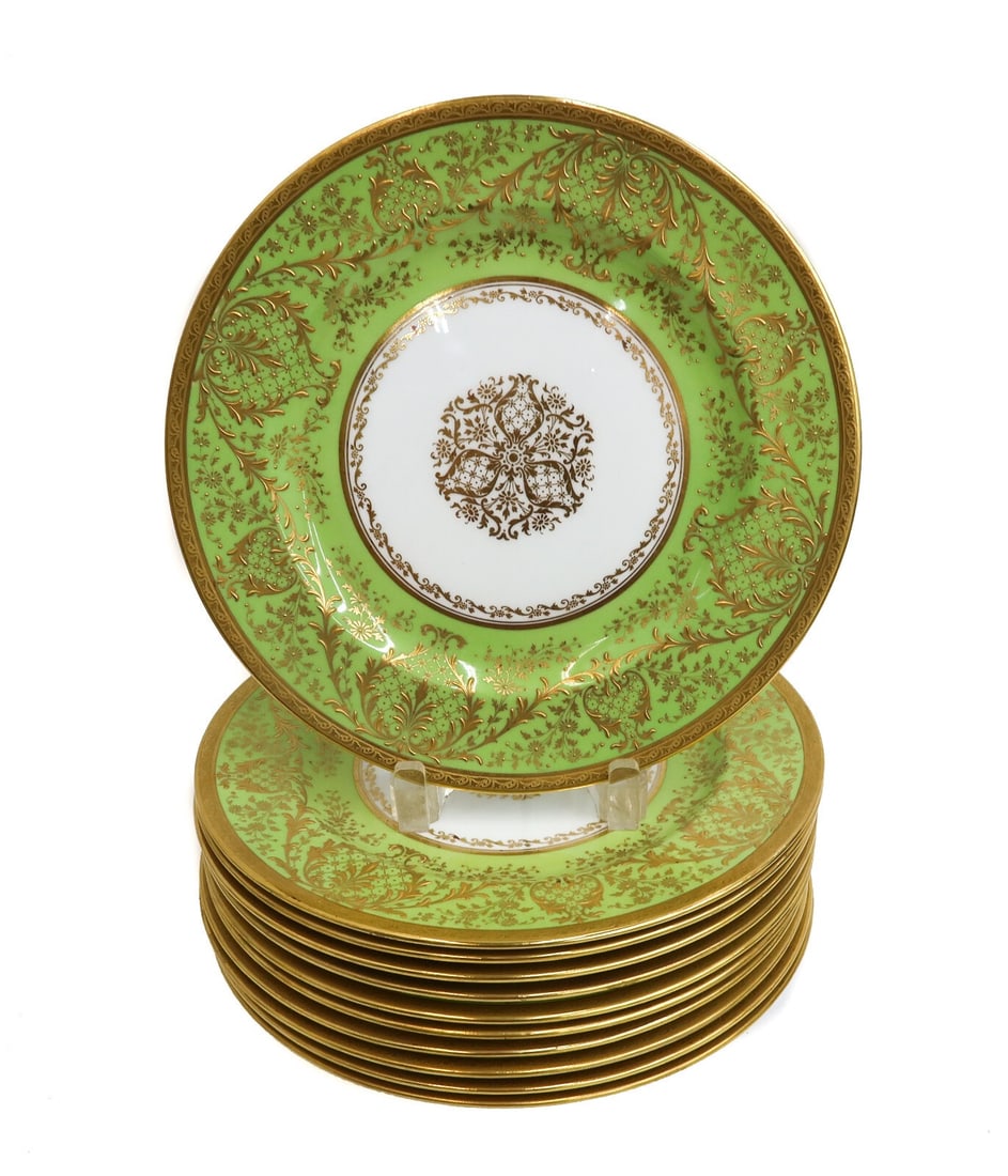 11 Royal Doulton England Green and Gilt Porcelain Dinner Plates circa 1910: 11 Royal Doulton England porcelain dinner plates circa 1910. A yellow green ground with gilt foliate leaves to rim and an emblem to center. Royal Doulton England mark to underside and retailed by Ovin