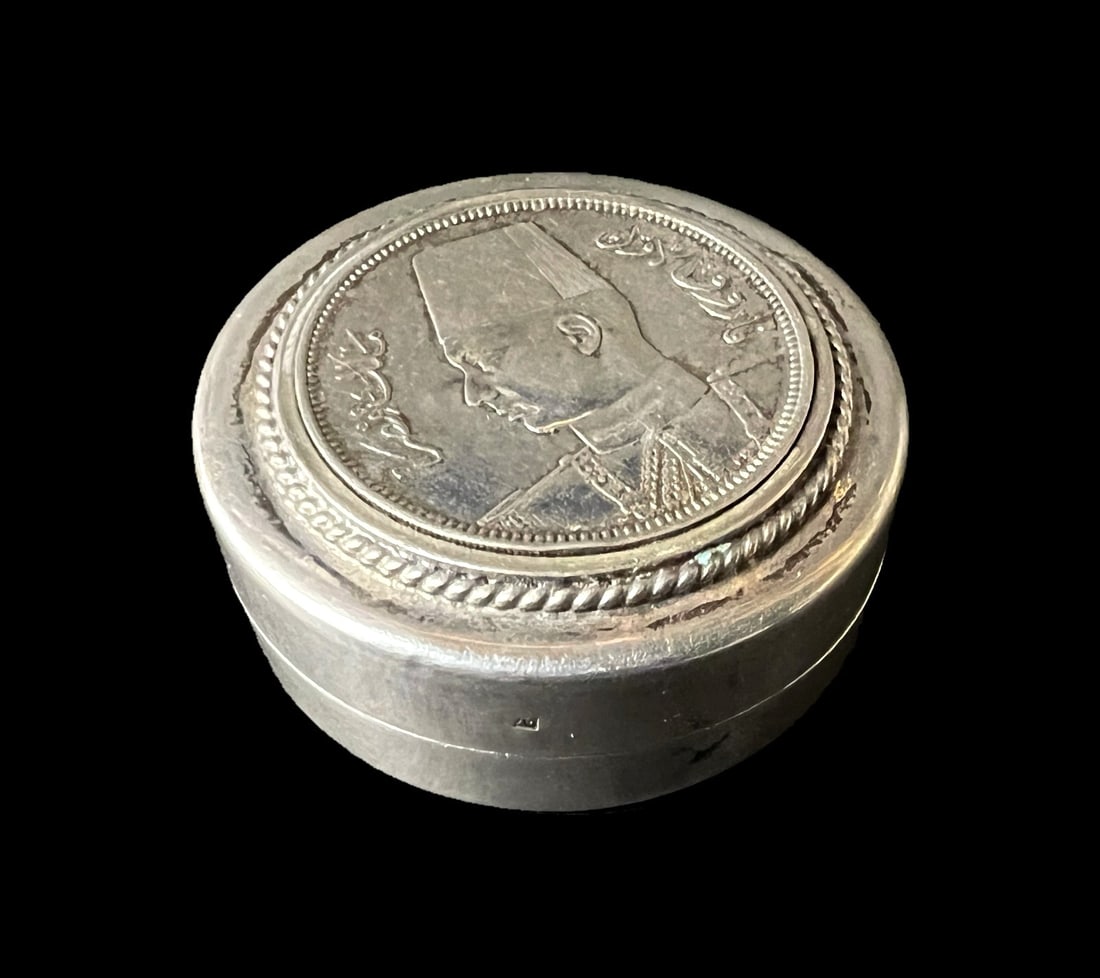 King Farouk 1939 10 Qirsh Coin 800 Silver Pill box: King Farouk 1939 10 Qirsh Coin 800 Silver Pill box c1940-50. Hallmarks on bottom and side Measurements: Approx. 31.48grams total; 1.5 in diameter x 0.75 inches height Condition: Very good condition, s