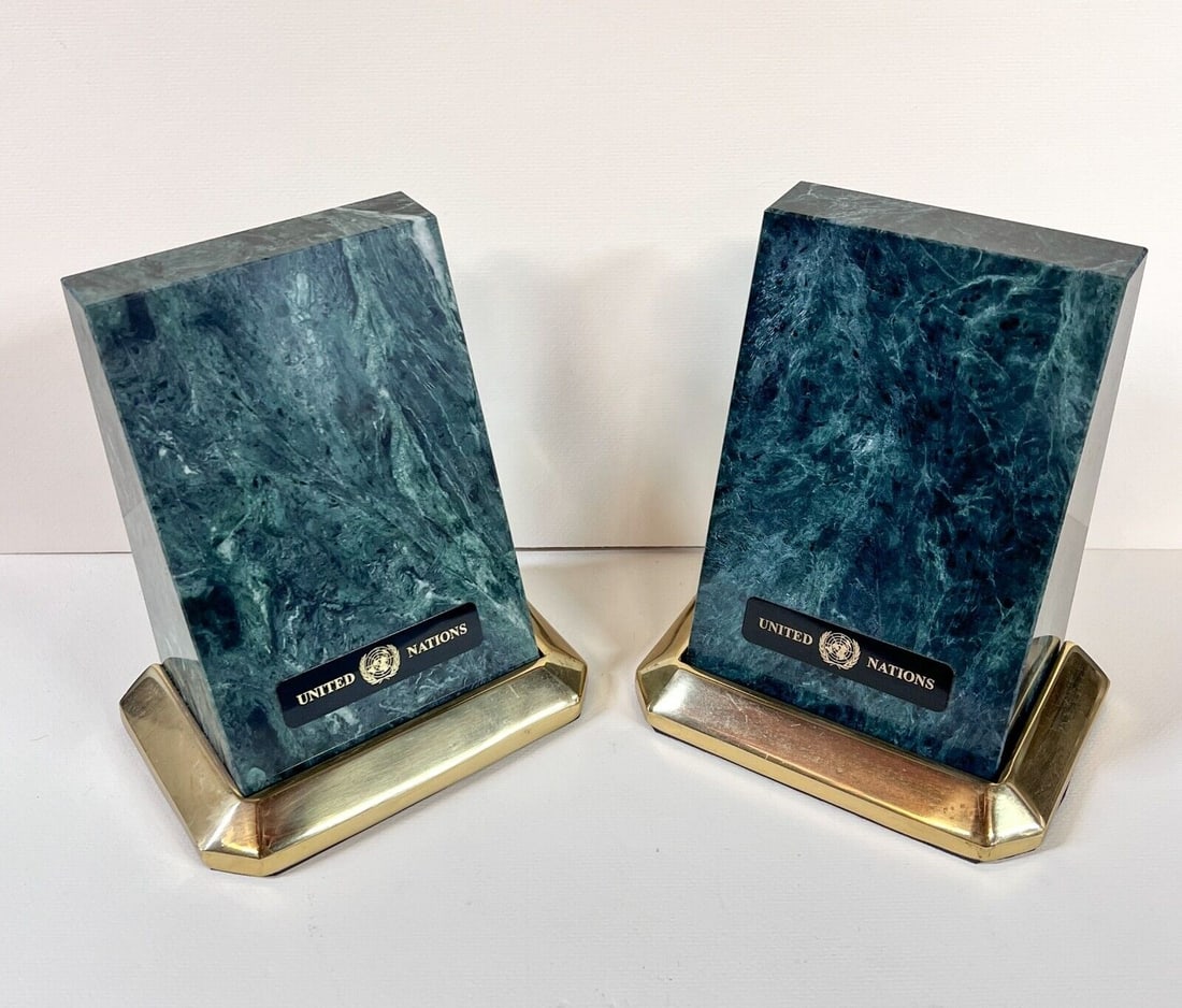 Vintage Pair of United Nations Green Stone Marble Bookends with Brass bases: Vintage Pair of United Nations Green Stone Bookends with Brass bases, c1970. 10.9lbs Measurements: Approx. each 6.25 x 5.5 x 3.625 inches Condition: Great condition, some oxidation to brass. Domestic