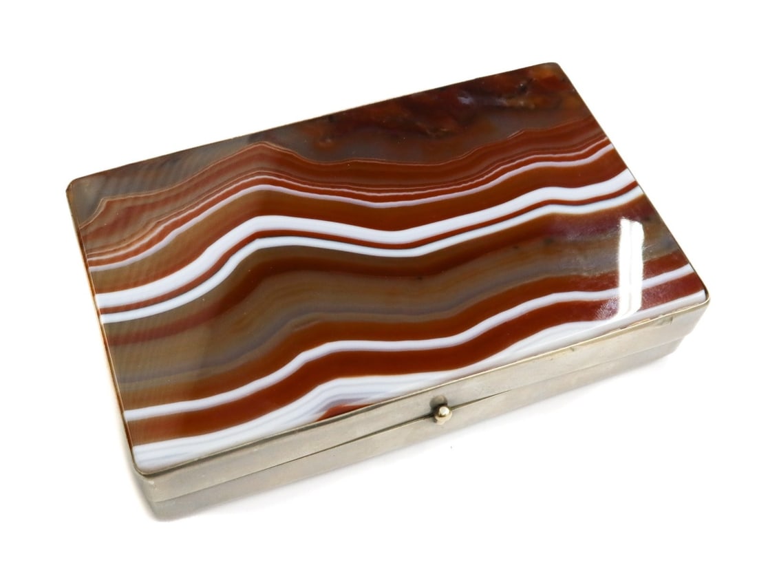 Silvered Metal Banded Agate Box Early 20th Century: Silvered metal banded agate box, Early 20th Century. Multi-colored orange agate stone to top and base lid. Unmarked Weight: Approx. 1 lbs Measurements: Approx.4.4 inches x 2.75 inches x 1 inches tall