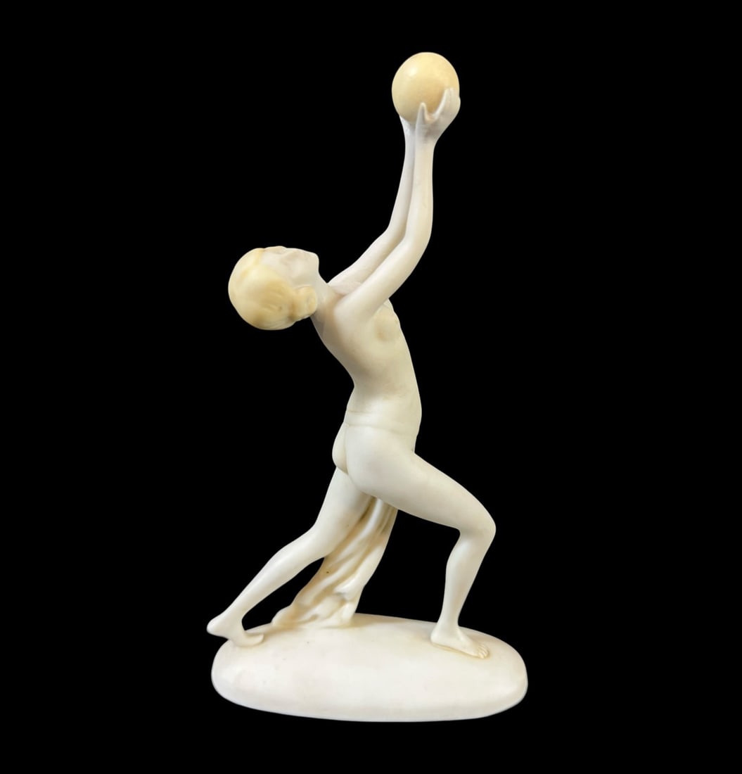 Continental Bisque Porcelain Art Deco Figurine c1930: Continental Bisque Porcelain Art Deco Figurine, diminutive nude with sphere. c1930. White with yellow details. Impressed numbers on underside. Restoration to hands. Measurements: Approx. 5.5 inches to