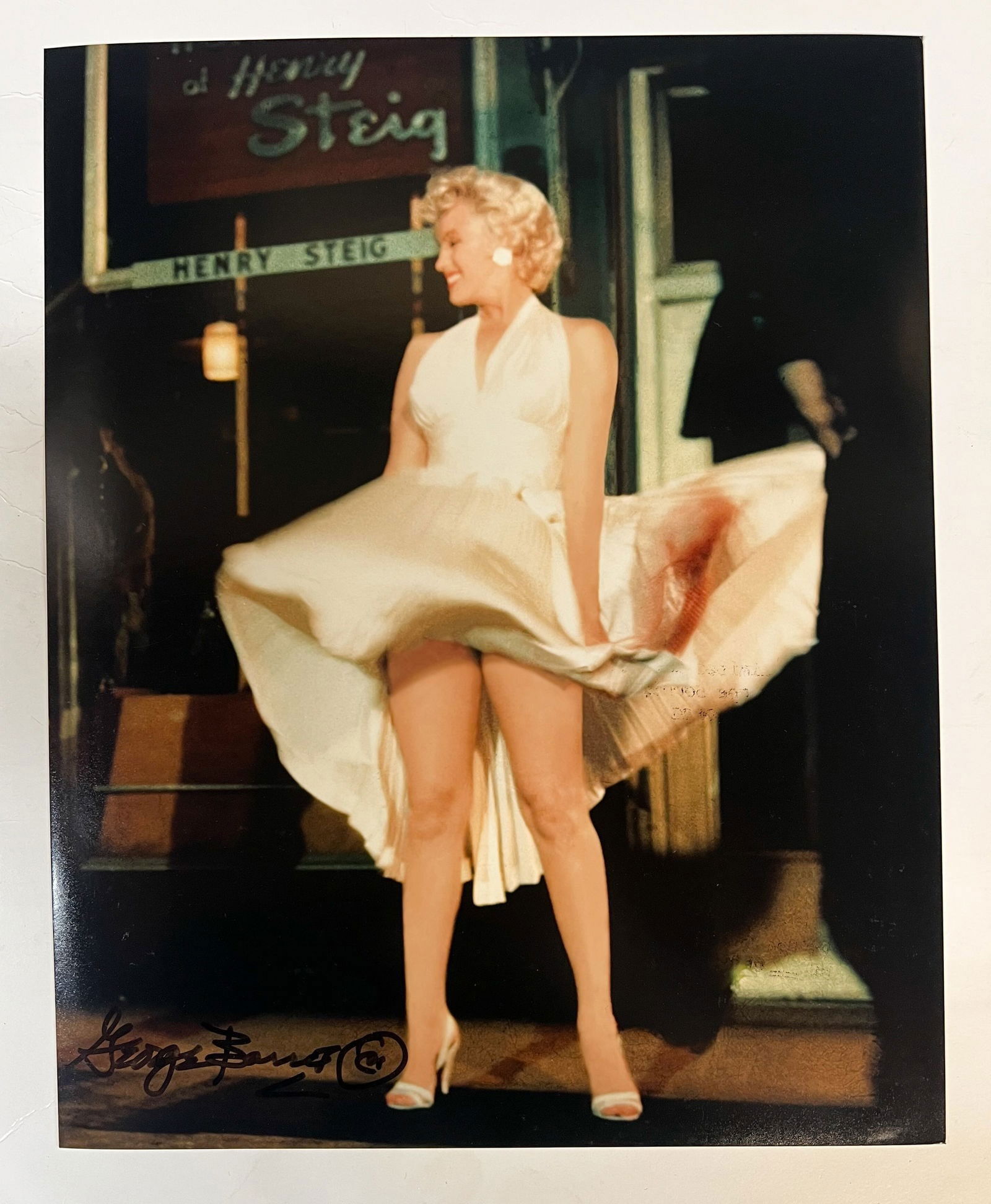Color Photograph Marilyn Monroe Seven Year Itch George Barris: A limited edition George Barris color photograph of Marilyn Monroe. Signed by George Barris in marker (lower right). Stamped and numbered on reverse. An iconic image of Monroe in a white dress, standi