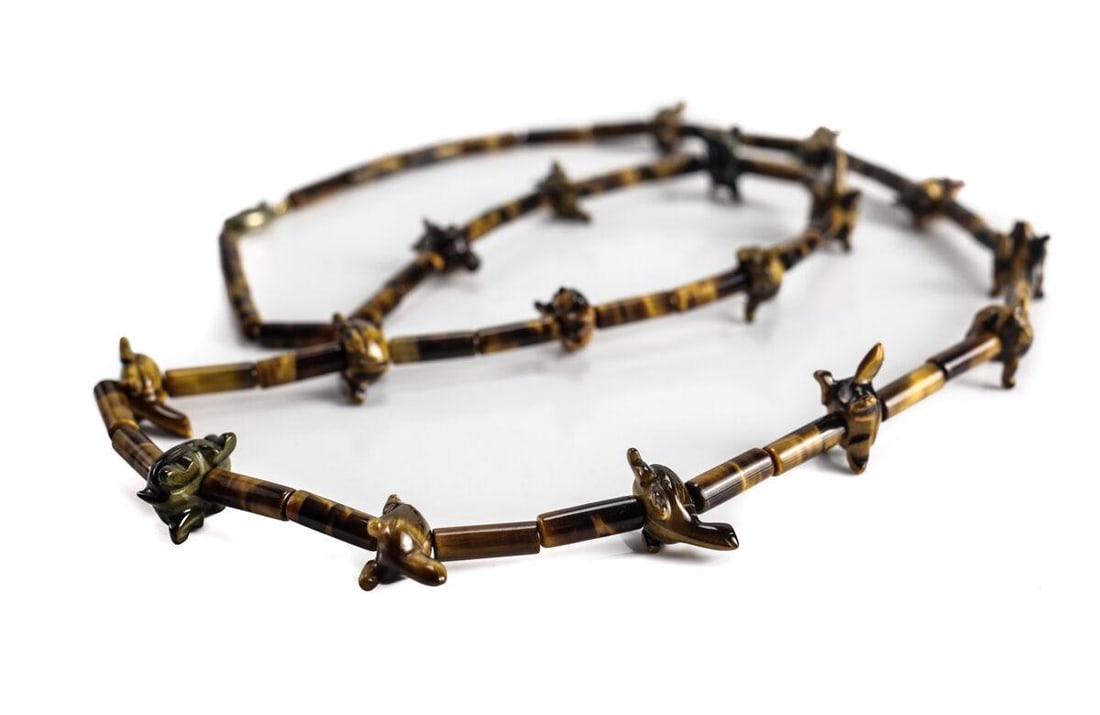 32in Tiger Eye Gemstone Necklace with hand carved Turtle Form Beads. c1960: 32inches Tiger Eye Gemstone Necklace with hand carved Turtle Form Beads. Tube shape beads, interspersed with small turtle beads. Sterling Silver filigree clasp, marked 'silver'. Tube beads 4mm diamete