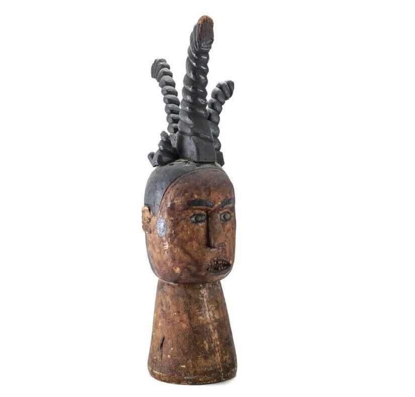 Large African Hand carved wood bust open mouth teeth: Distinctive African Hand carved wood bust, open mouth, teeth, tall hair or headdress. Nail head eyes and teeth. 4lbs Measurements: Approx. 25in height x 6 x10. Condition: Some loss to hair/headdress a
