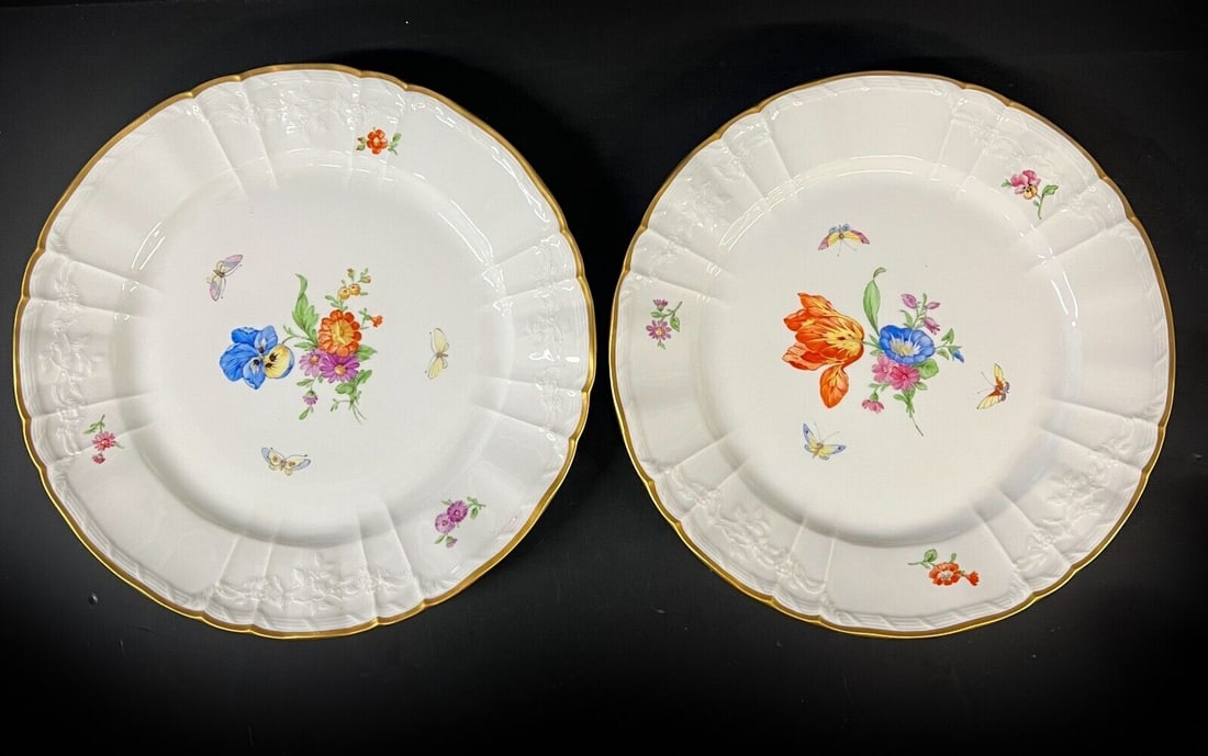 2pc KPM Porcelain Plates hand painted florals 19th Century: a pair of KPM Porcelain Plates, hand painted florals and butterflies, embossed floral rim, gilt trim, makers mark on underside, with wall hanger on back. 19th Century 4.5lb Measurements: Approx. 10.37