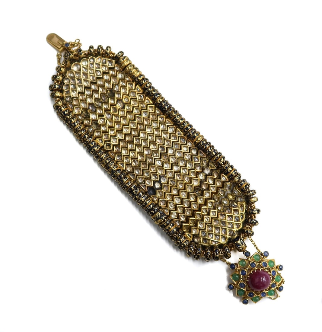 Vintage Indian High Karat Gold Polki Diamond Ruby Emerald and Sapphire Bracelet: Vintage Indian high karat gold polki diamond wrap bracelet. Around 238 polki diamonds ranging from different sizes encrusted to band. Clasp with cabochon ruby center and alternating round cabochon eme