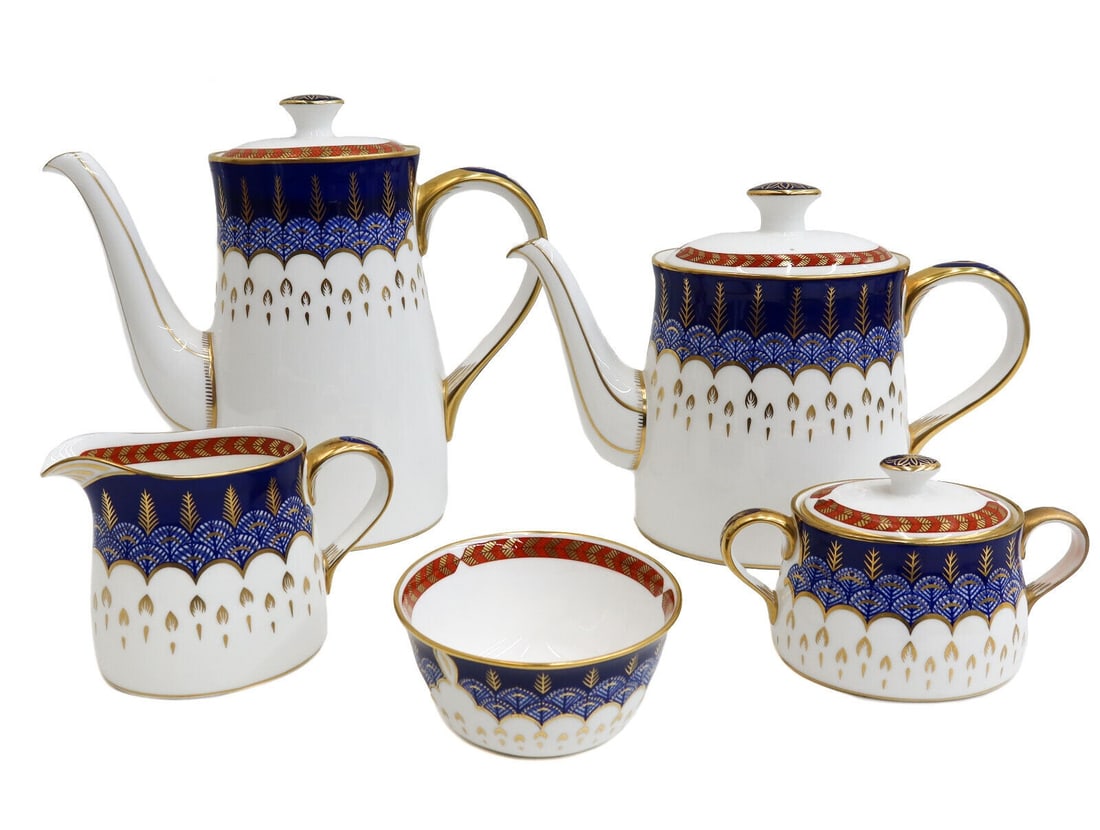 Royal Crown Derby England Porcelain Tea and Coffee Set in Quail Late 20th C: Royal Crown Derby England Porcelain Tea and Coffee Set in Quail, Late 20th Century. Rust red and gold feathered rim with a blue and gold blue quail feathered emblem to center. Royal Crown Derby marks