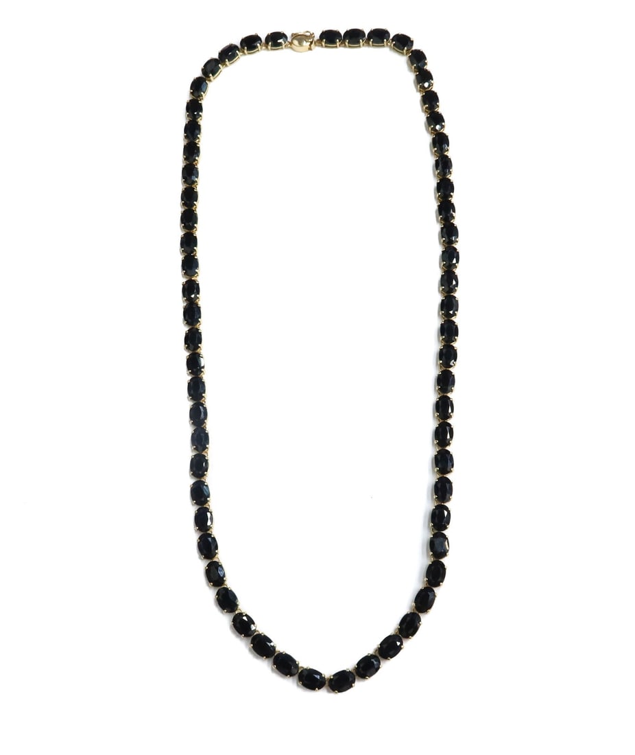 14k Yellow Gold and Dark Blue Sapphire Single Strand Necklace: 14k yellow gold and dark blue sapphire single strand necklace. 61 sapphires to strand measuring approximately 7mm x 4.9mm x 3.2mm and weighing approximately 53.68 carats. Marked 14k to clasp Weight: A