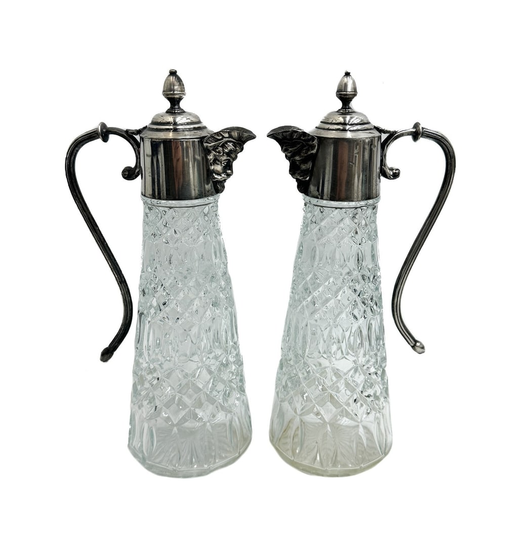 Pair Silverplate and Cut Glass Claret Wine Decanters Bacchus Spout: Pair silverplate and cut glass claret wine decanters. Etched diamond designs to glass with an etched bacchus head to spout. Marked silverplate to handle. Weight: Approx. 2 lb Measurements: Approx. 5.5