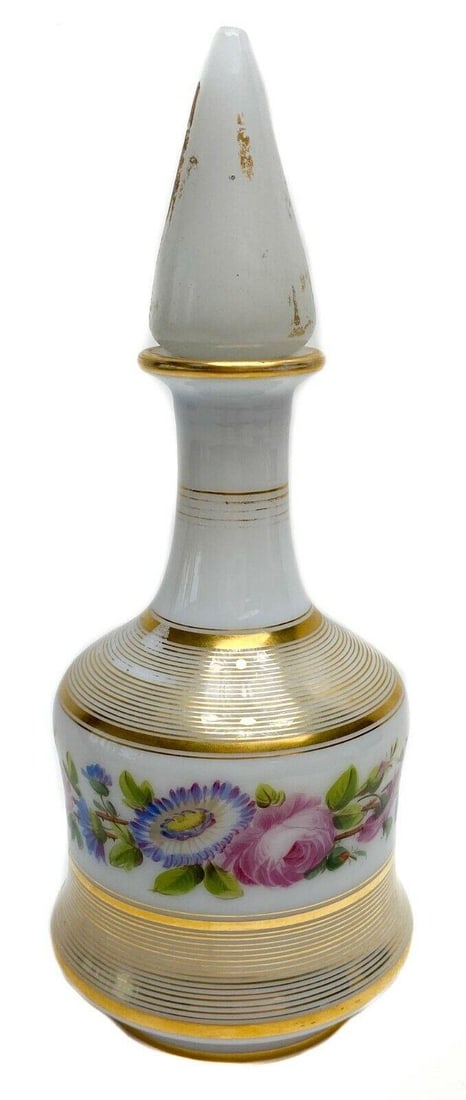 Opaline Hand Painted Floral Decanter with Gilt Decorations & Pointed Stopper: Opaline decanter with gilt & floral decorations and pointed stopper. Weight: Approx. 1.6 lbs Measurements: Approx. 5.4 in. diameter x 11 in. tall Condition: Good condition. Cork stopper is missing and