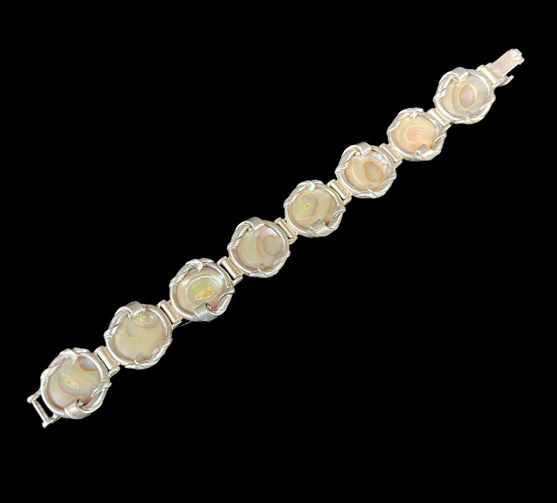 Sterling Silver Mother of Pearl Art Nouveau style Bracelet: Sterling Silver Mother of Pearl Art Nouveau style Bracelet, leaf and scroll frame round mother of pearl. Marked Sterling Measurements: Approx. 34.72grams; 0.75 in x 7.375 in total length. 17.2cm circu