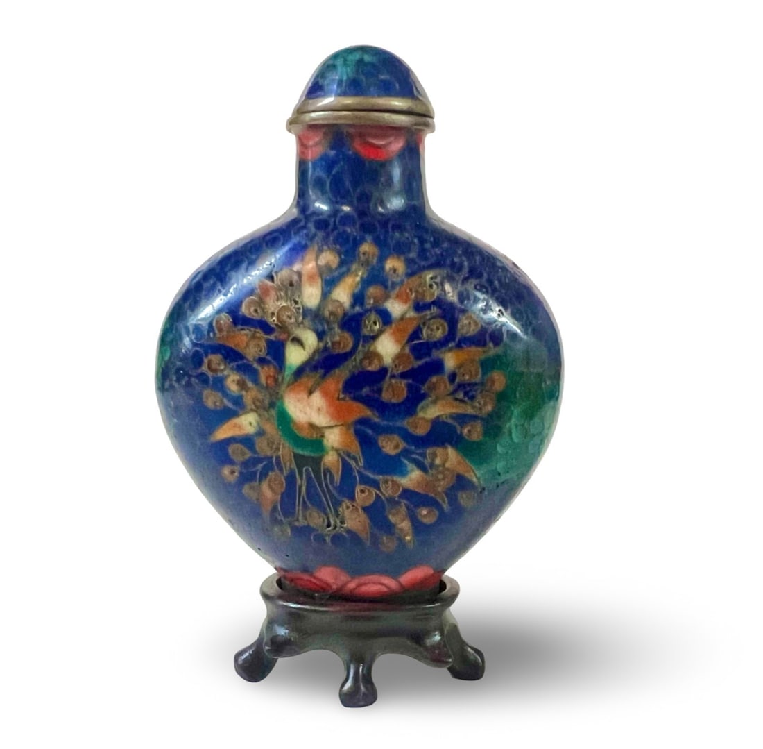 A Cloisonne Snuff Bottle with Peacock: A Cloisonne Snuff Bottle, likely late Qing Dynasty (1644-1912). Rounded spade form bottle, peacock design on both sides. With metal spoon and stand. Measurements: Approx. 2.75 in height x 2 x 1 inches