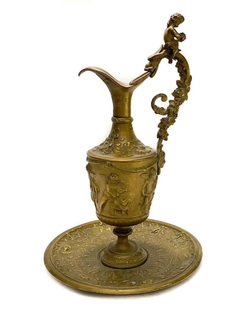 Patinated Gilt Bronze Decorative Ewer and Plate, 19th Century. Repousse Cherubs: Patinated gilt bronze decorative ewer and plate, 19th Century. Repousse cherubs to the exterior of the ewer and to the plate. Leaf vines to the handle. Weight: Approx. 6 lbs Measurements: Approx. 11.2