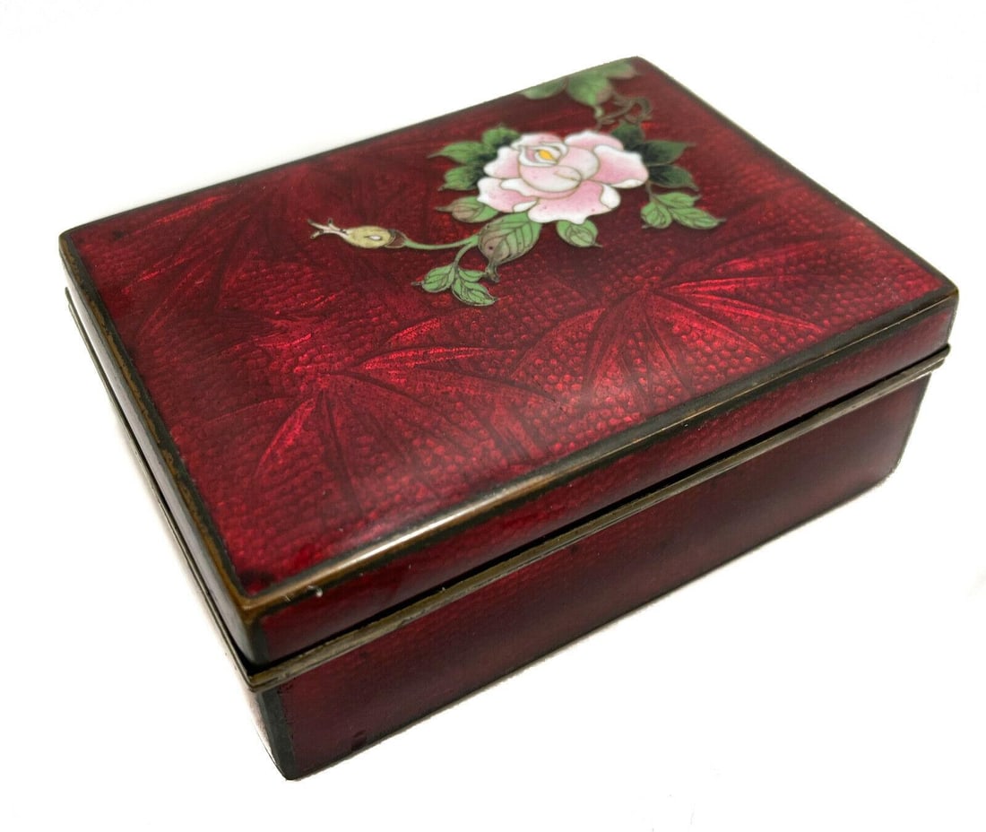 Inaba Nanaho Japanese Red Cloisonne Enamel Box: Inaba Nanaho Japanese red cloisonne enamel box. Red foil cloisonne with florals to the lid. Marked to the interior. Weight: Approx. 1 lbs Measurements:: 4.625 inches x 3.5 inches x 1.625 inches Condit