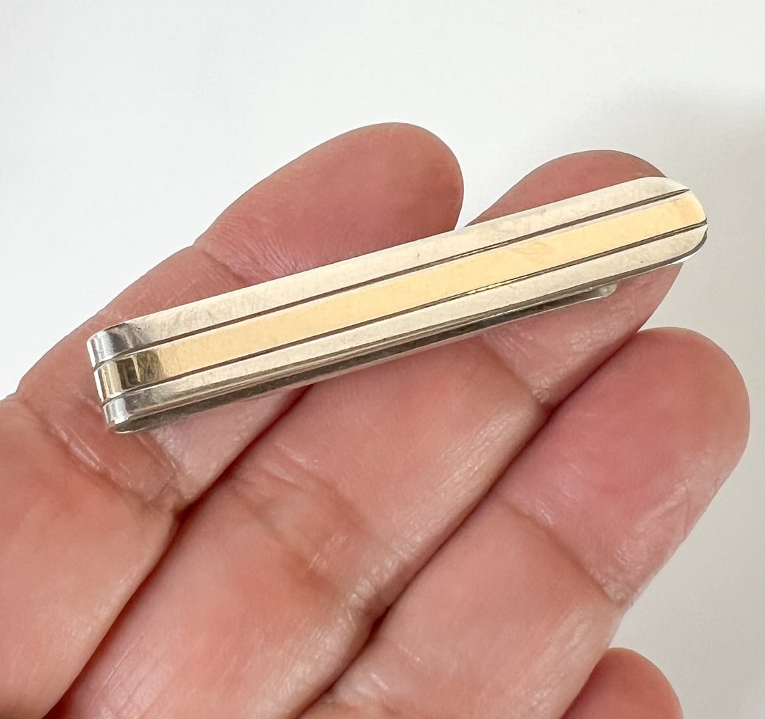 Vintage Tiffany & Co Sterling Silver and 14k Yellow Gold Tie Clip Bar: Vintage Tiffany & Co Sterling Silver and 14k Yellow Gold Tie Clip / Bar. Slim design with gold stripe. Makers mark on reverse. Measurements: Approx. 7.62grams; 2 x 0.3125 inches Condition: Very good c