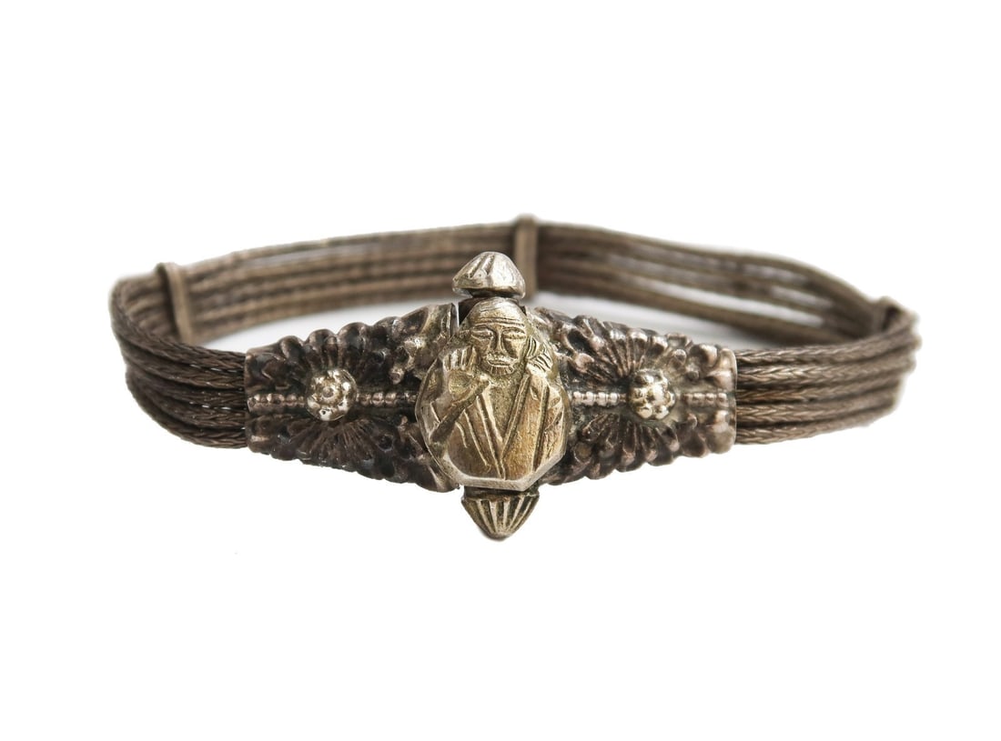 Chinese Silver Braided Cord Bracelet: Chinese silver braided cord bracelet. 5 twisted cords with a figure of apparently Buddha to twisted clasp. Unmarked, tests for 90% silver. Weight: Approx. 21.41 grams Measurements: Approx. 7.5 inches 