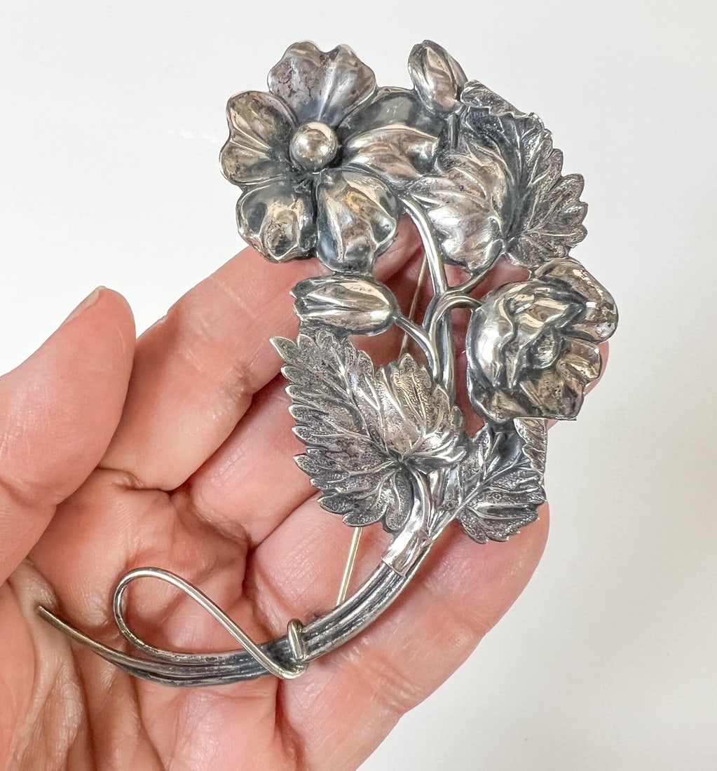 Large Vintage Sterling Silver Repousse floral brooch c1940-50: Vintage Sterling Silver Repousse floral brooch c1940. A sprig of flowers, leaves and buds. Marked 'Sterling' on reverse. Brooch tested silver; pin and closure not testing as silver. Measurements: Appr