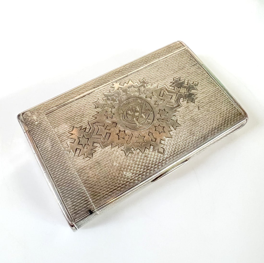 Russian 84 Silver Cigarette Box with hinged match safe Late 19th Century: Russian Silver Cigarette Box by Ivan Sveshnikov , with match safe, textured striker and tinder cord holder; hand chased design as a stylized patterned sash, and interlocking ring motifs. Gilt interior