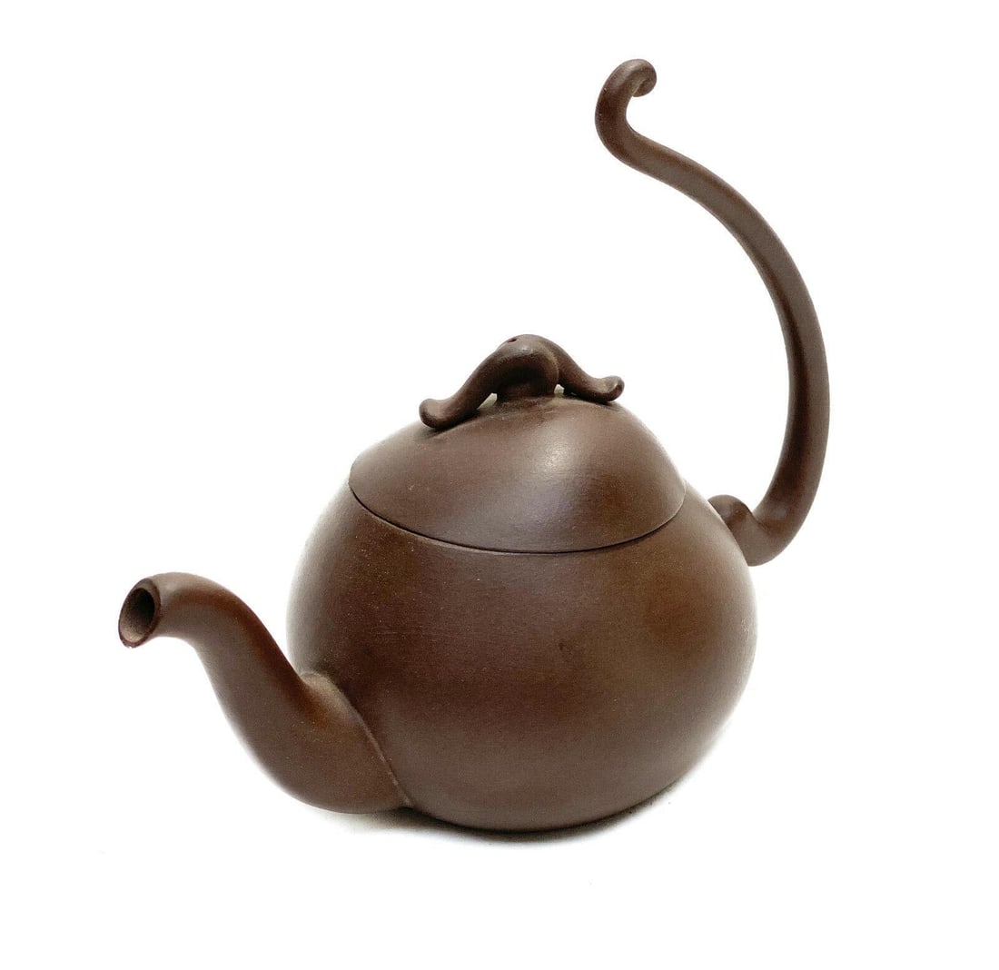 Chinese Ceramic Miniature Teapot: A finely made Chinese ceramic miniature teapot with an elongated handle. Chinese marks to the underside base. Weight: Approx. 0.25 lb Measurements: Approx. 5.625 inches x 3 inches x 4.5 inches tall Co